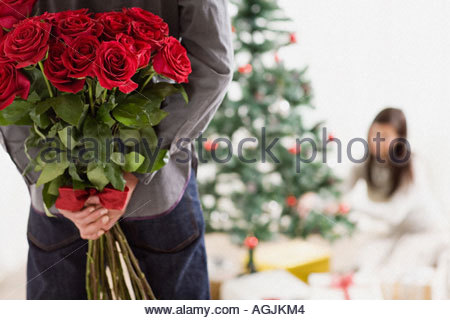 man-holding-surprise-gift-of-roses-agjkm4
